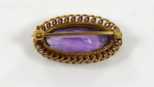 A 14k and amethyst set oval brooch, 25mm, gross weight 3.6 grams. Condition - fair.